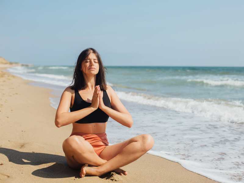 woman-meditating-by-the-beach-as-self-care-practices-for-mothers