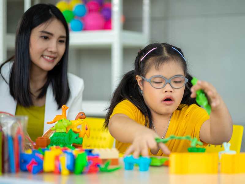 mom-with-daughter-on-wheelchair-fixing-toys