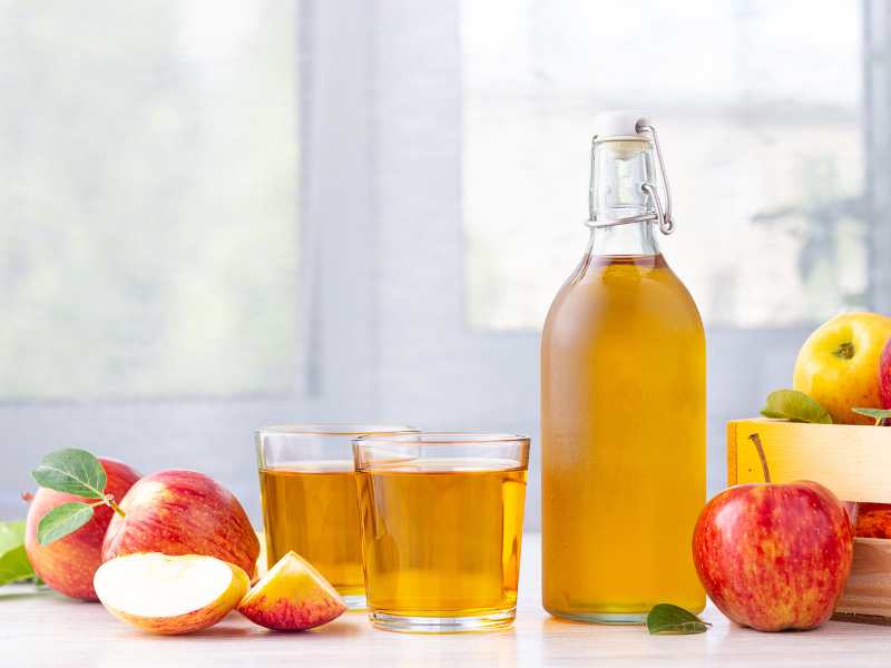 apple-cider-vinegar-in-glass-bottle-and-fresh-red-apples-on-the-table