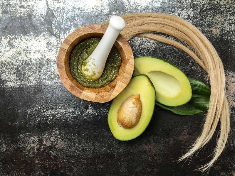 flat-lay-composition-with-avocado-and-natural-cosmetics-for-hair-on-grunge-background