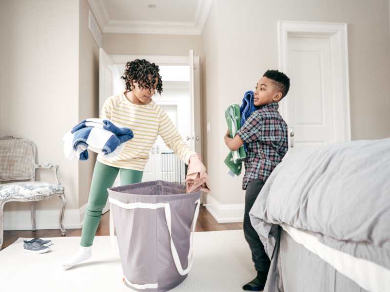 little-boy-organizing-laundry-basket-with-mom