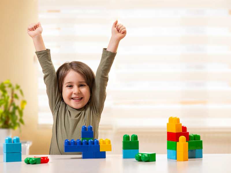 little-feeling-great-and-happy-with-bricks-blocks-on-the-table