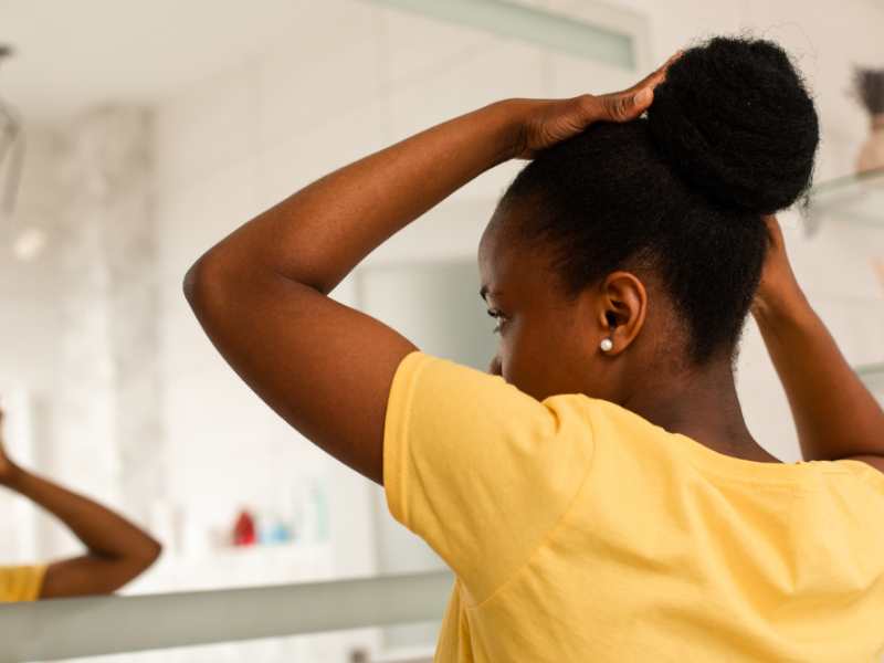 woman-on-yellow-tying-up-her-hair