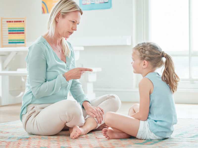 shot-of-woman-and-daughter-sitting-on-the-floor-as-she-points-at-the-kids-without-yelling