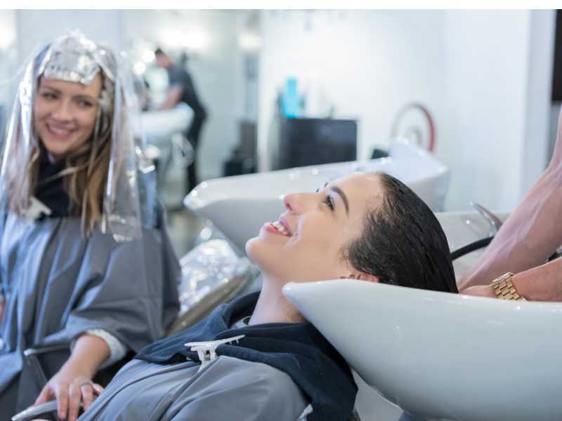 woman-relaxes-as-hair-stylist-rinse-her-hair-with-tea-solution