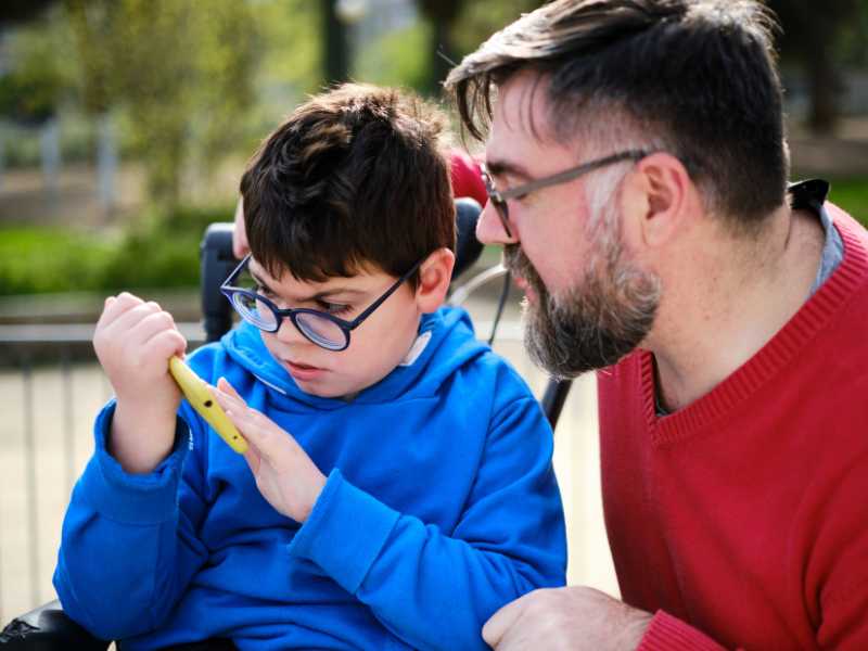 father-with-son-on-a-wheelchair-talking-dad-caring-for-his-special-child