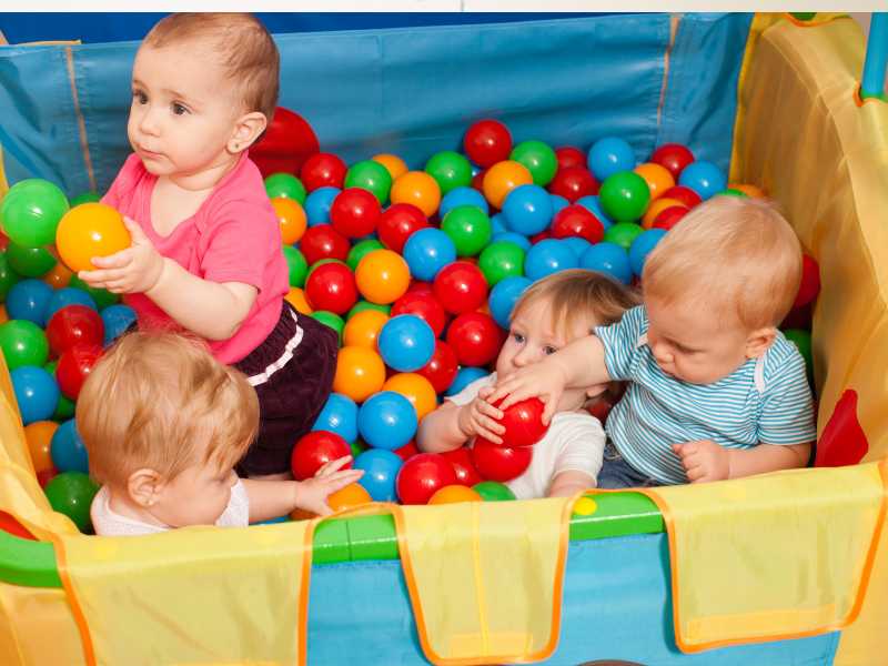 cute-babies-playing-with-multicolor-small-boys-inside-a-playpen