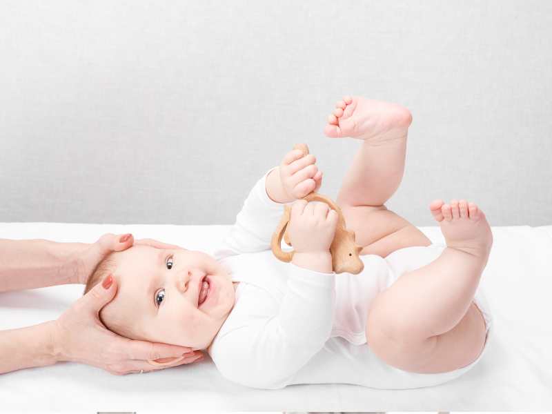 a-baby-on-white-lying-with-legs-up-and-smiling