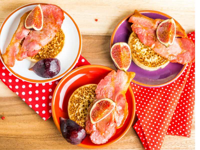 a-stack-of-crumpet-with-bacon-figs-and-maple-syrup-on-wooden-tray