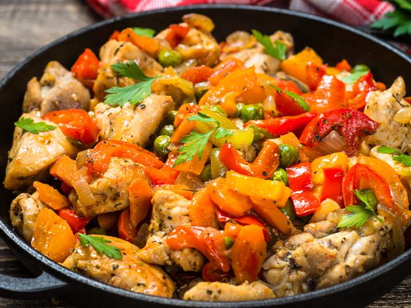 chicken-stir-fry-and-vegetables-in-a-black-pan