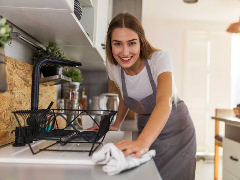 woman-cleaning-kitchen-counter-an effective-cleaning-routine