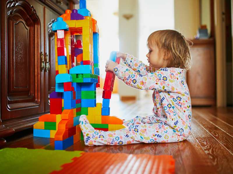 little-girl-in-pajamas-playing-with-bricks