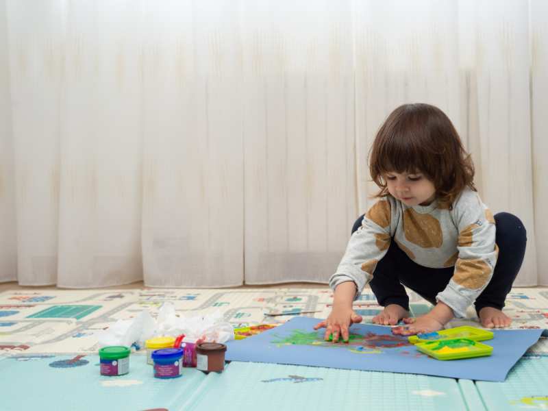 little-girl-doing-finger-painting-in-a-playroom-a-safe-indoor-activities-for-toddlers