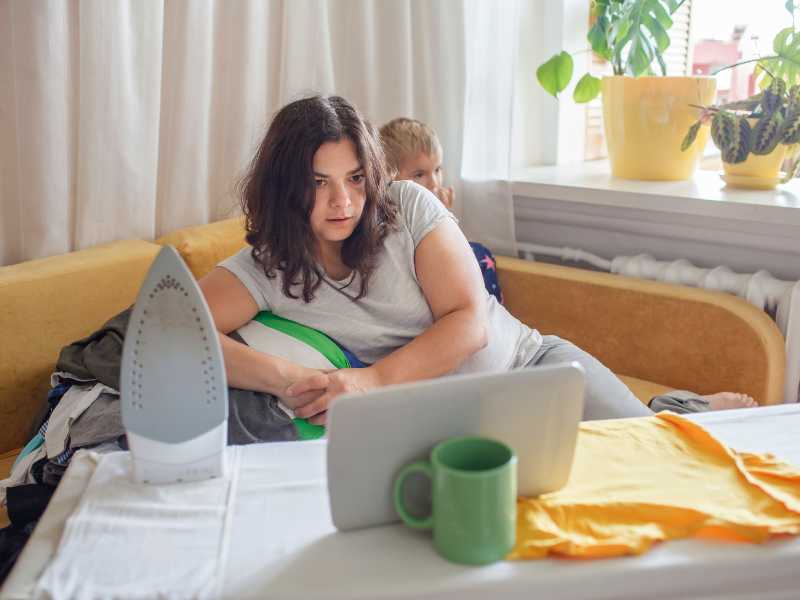 a-woman-managing-chores-and-rest-with-a-baby-behinde