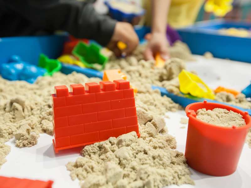 kids-playing-plastic-molds-toys-with-sand-on-sandbox