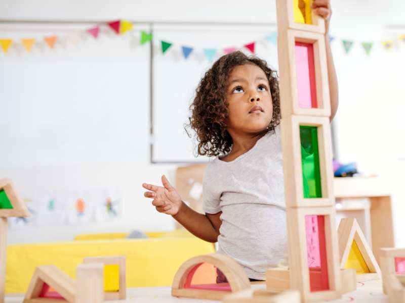 toddler-building-tower-with-wooden-blocks