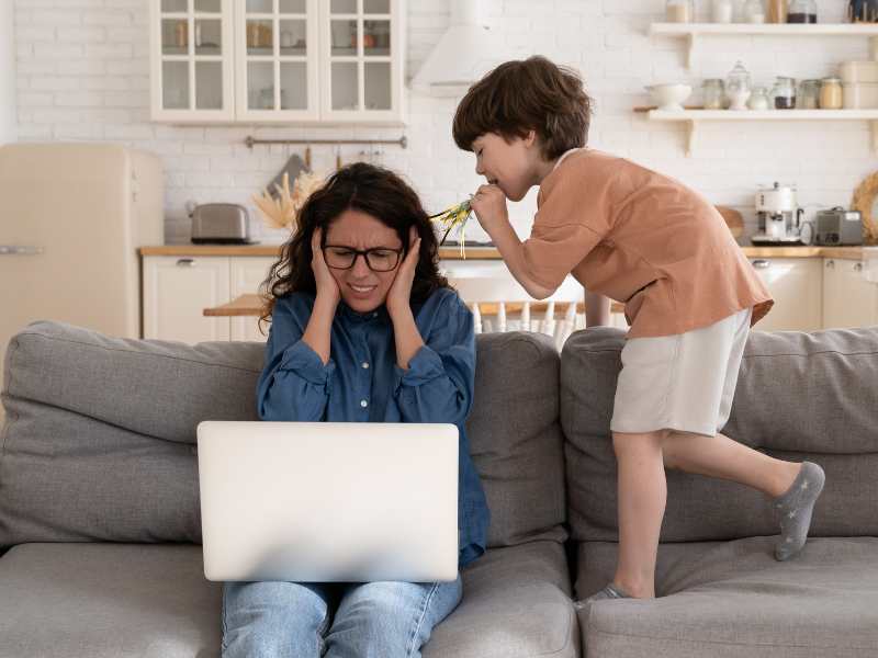 mom-covering-her-ears-from-noise-coming-from-the-son