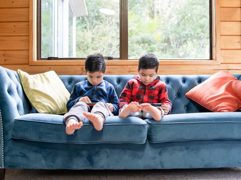 two-kids-on-couch-with-tablets