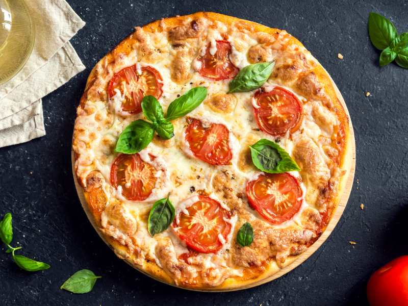 pizza-margherita-with-tomatoes-and-basil-on-a-blackstone-background