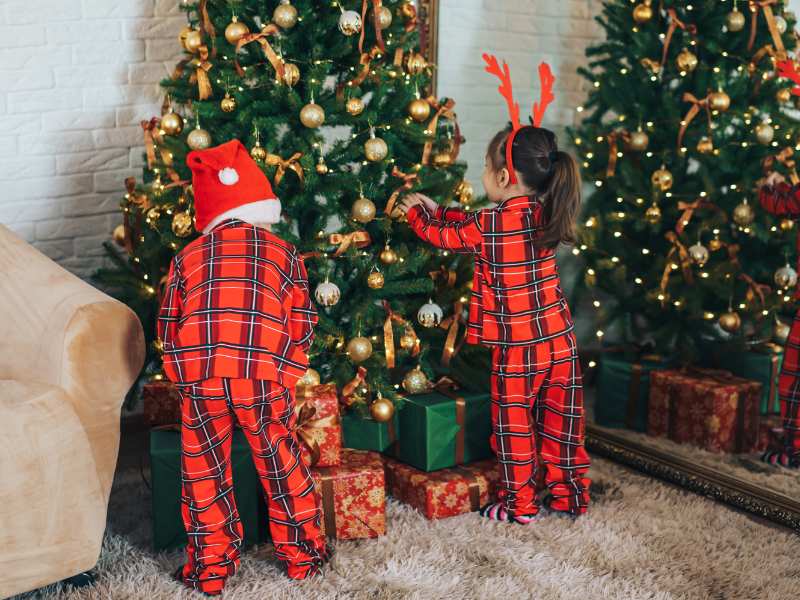 children-in-matching-pajamas-decorating-Christmas-tree