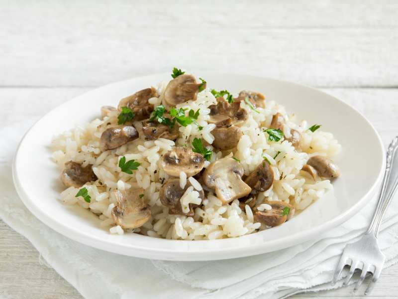 mushroom-risotto-with-parsley-on-white-wooden-background