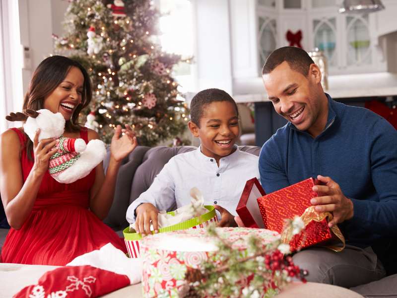 family-opening-Christmas-gift-together-at-home