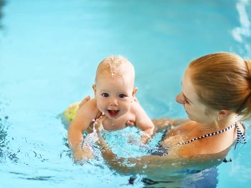 mother-teaching-baby-how-to-swim-in-pool-to-encourage-healthy-development