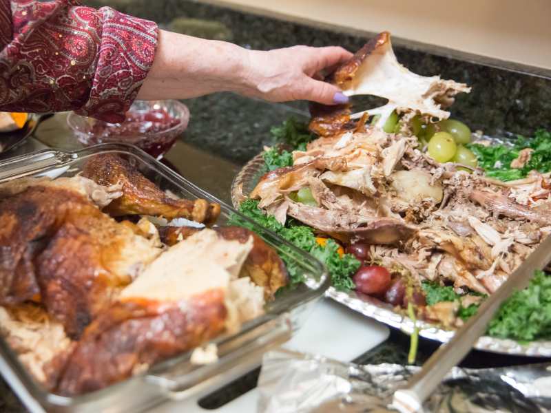 woman-covering-a-glass-of-meat-leftovers-in-tin-foil