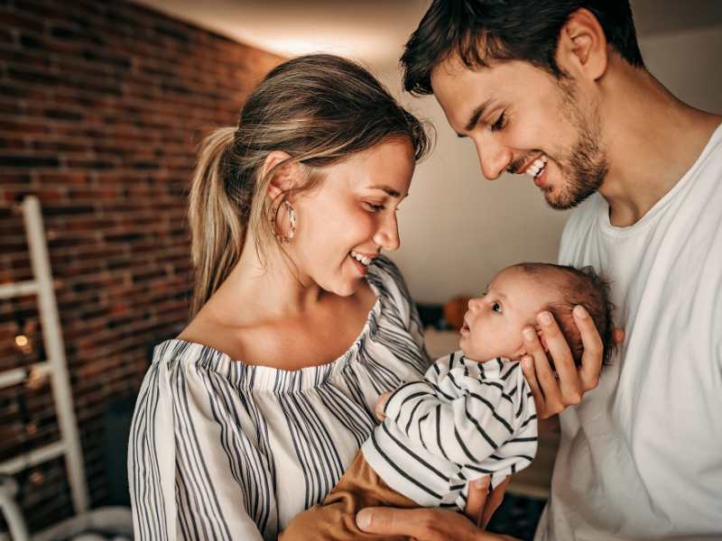 a-woman-and-and-man-holding-their-baby-a-way-to-encourage-healthy-development-in-babies