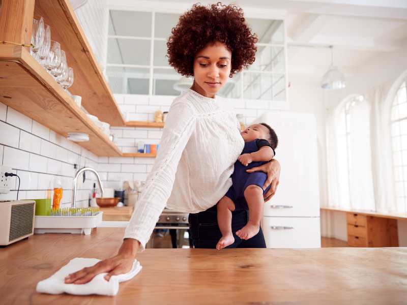 a-woman-cleaning-and-carrying-baby-at-the-same-time