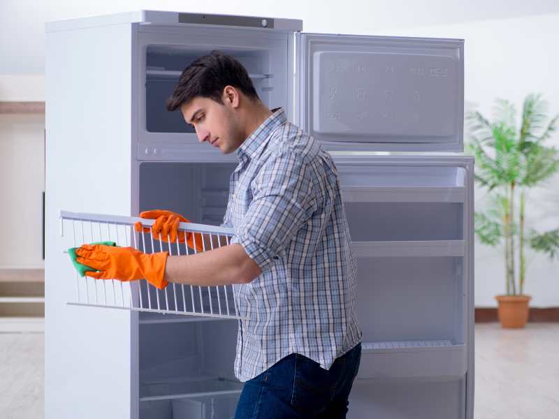 man-cleaning-out-fridge-to-maintain-a-well-organized-home