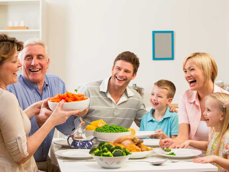 family-sit-down-to-dinner-together-around-a-kitchen-table