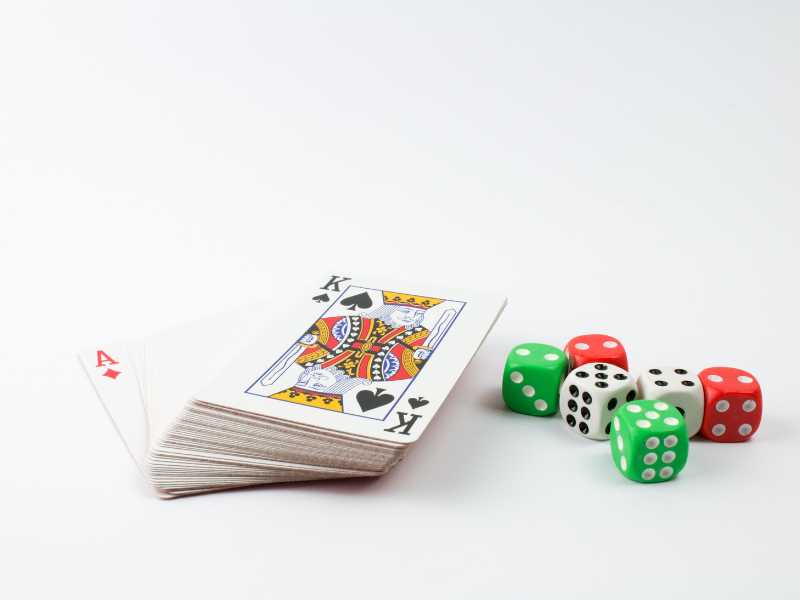 a-board-game-with-red-green-and-white-dice-on-a-white-surface