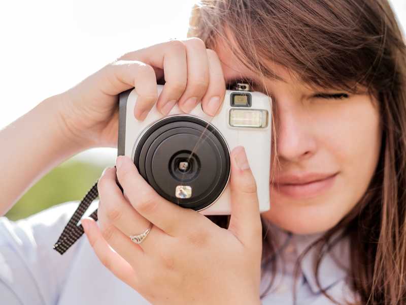 woman-holding-an-instant-camera