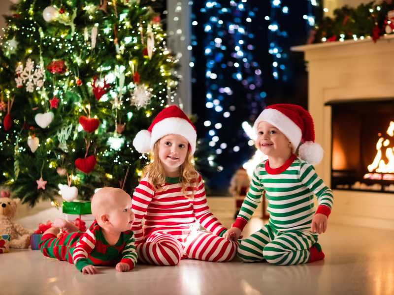 three-lovely-kids-on-Christmas-pajamas-sitting-on-the-floor