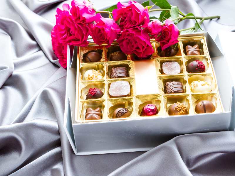 box-of-chocolate-with-pink-flowers-by-the-side-a-good-Christmas-gift-ideas