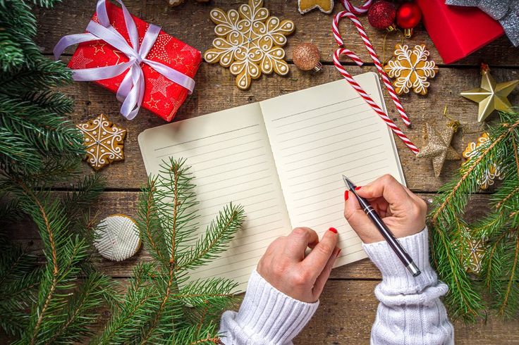 a-hand-with-a-pen-and-Christmas-decorations-accessories