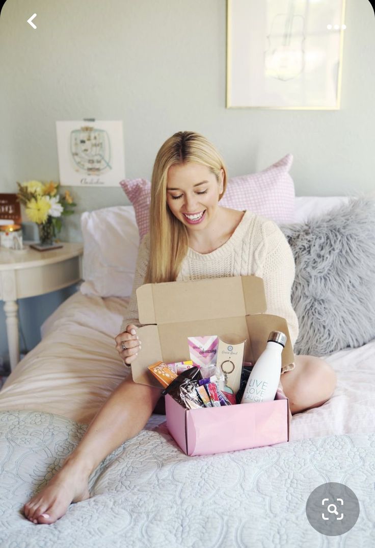 woman-sitting-on-the-bed-with-a-open-box-with-gifts