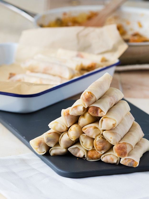 A-stack-of-uncooked-breakfast-spring-rolls-in-a-black-plate