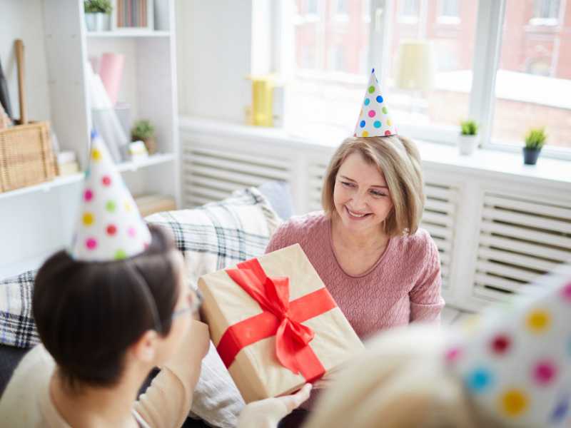 WOMAN-ACCEPTING-A-WRAPPED-GIFT-WITHRED-BOW-TIE