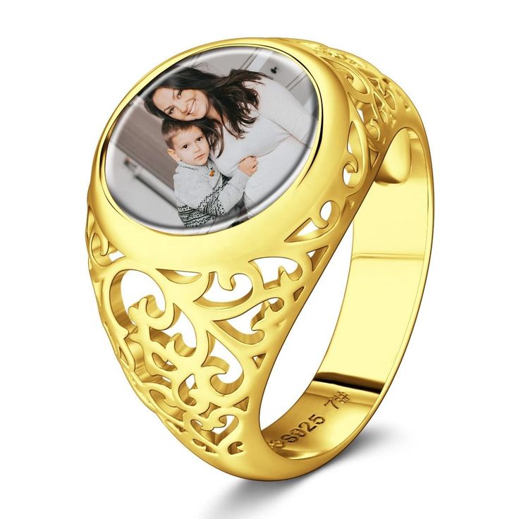 a-gold-color-mother-and-child-engraved-ring-on-a-white-surface