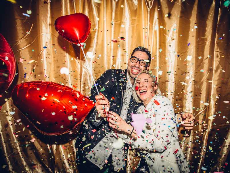 man-and-woman-with-red-balloons-on-a-gold-background