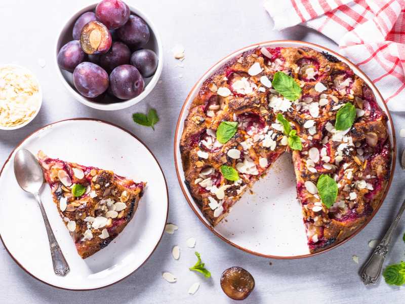 almond-flour-crust-with-berry-tart-in-a-white-plate-and-berries-in-a-white-cup