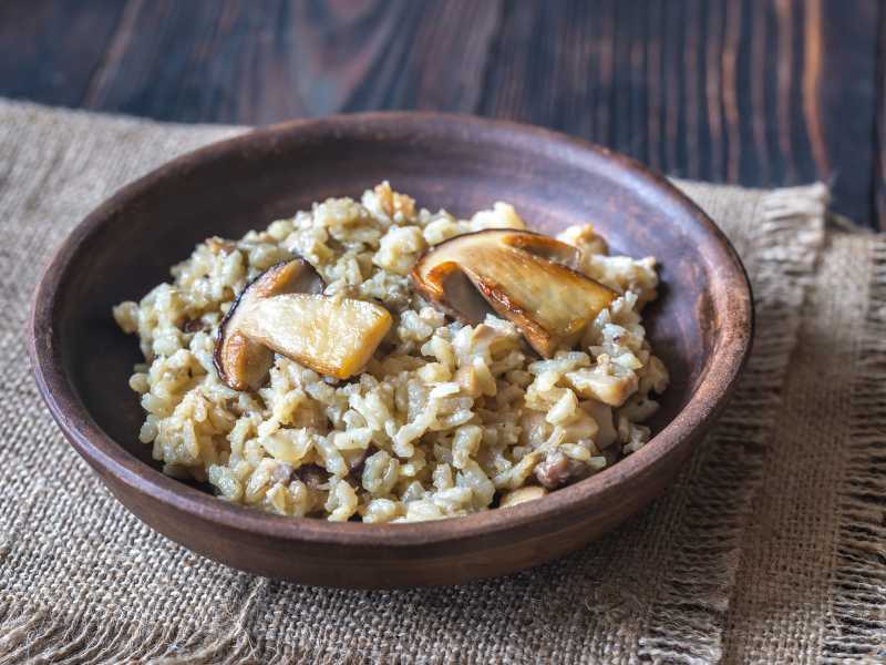 creamy mushroom-risotto-in-a-brown-bowl-on-a-napkin