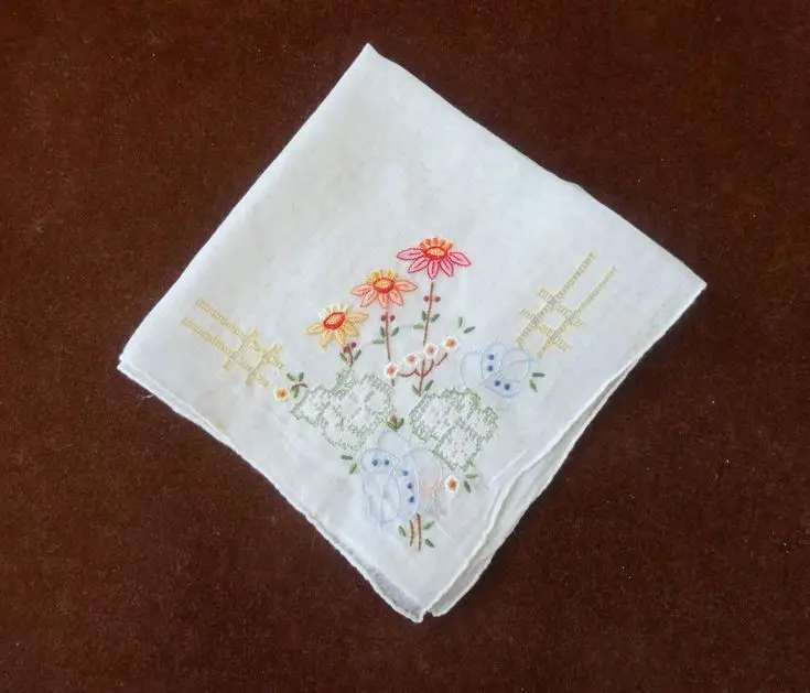 a-white-embroidered-handkerchief-on-a-brown-background