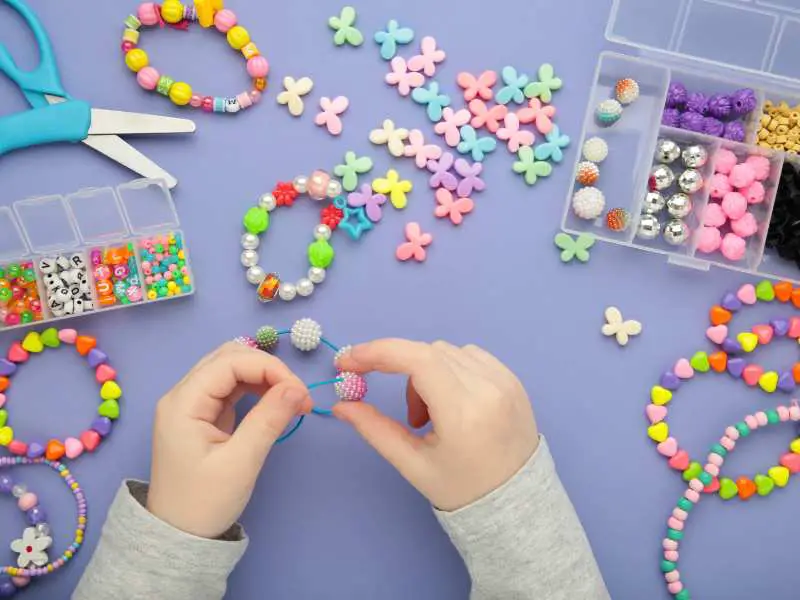 hand-making-beads-on-a-purple-background