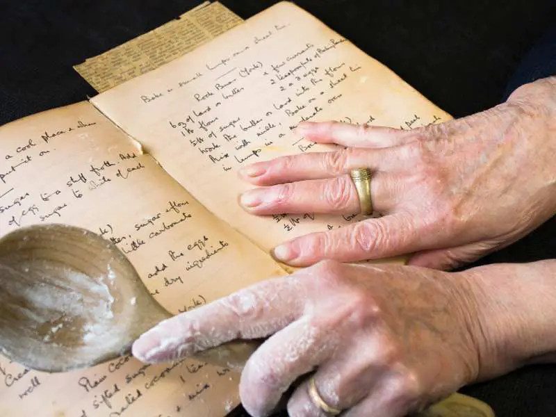 hand-with-a-cooking-spoon-and-a-recipe-book