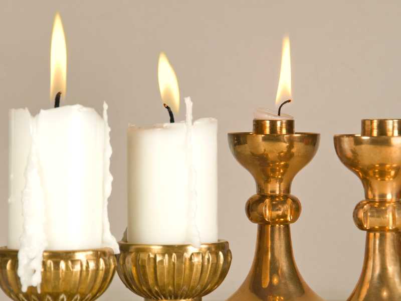 white-candle-on-a-gold-candle-stand