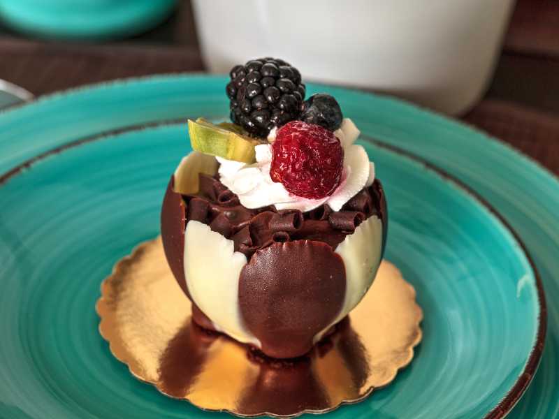 dark-chocolate-with-raspberry-garnish-with-cream-and-berries