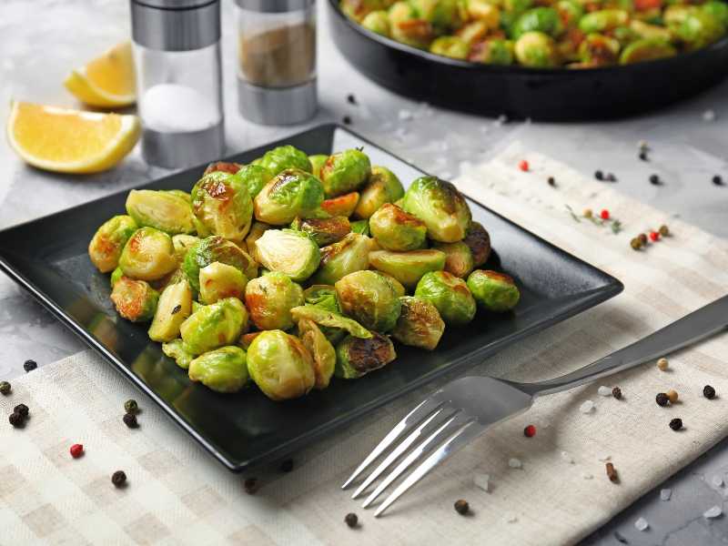 roasted-brussels-in-a-black-flat-bowl-set-for-dinner